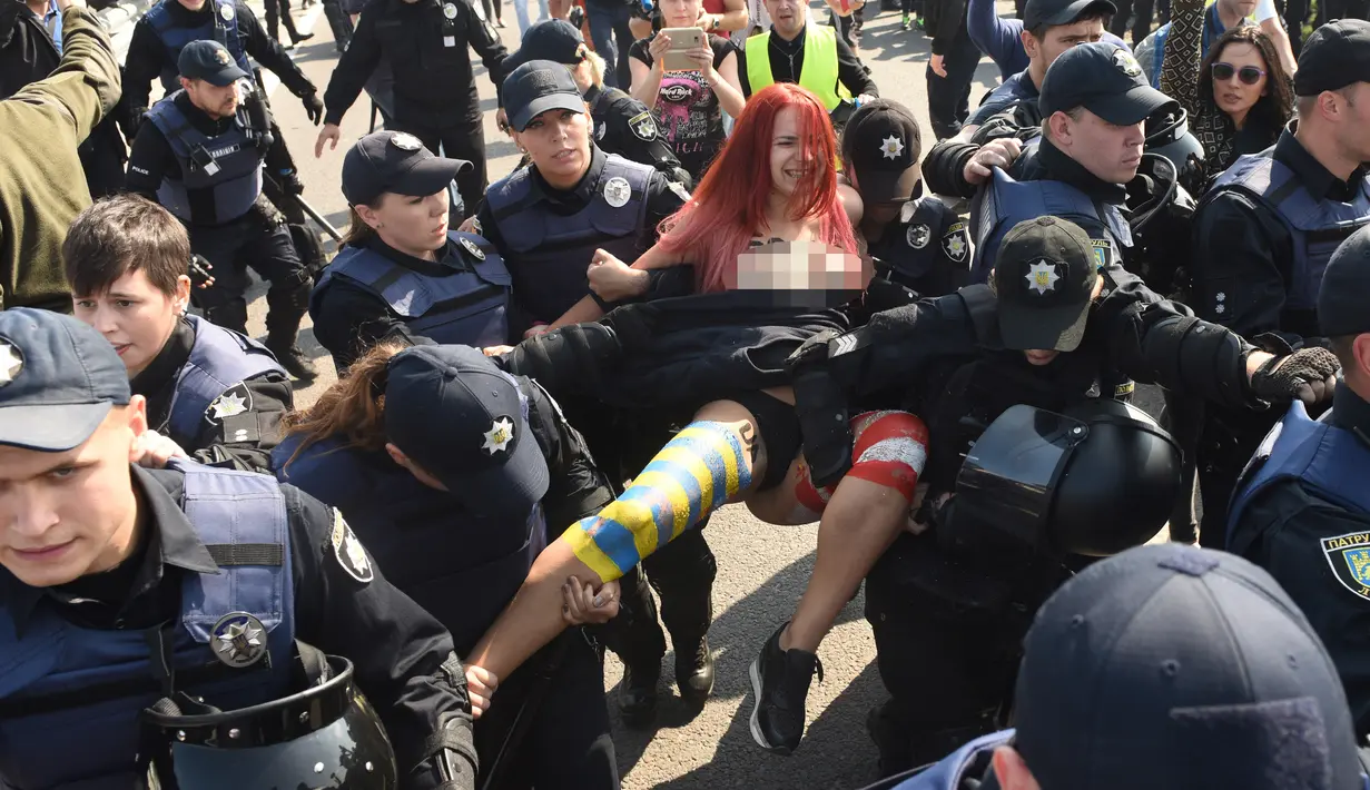 Polisi Ukraina menahan aktivis perempuan Femen di titik cek Krakovets di perbatasan Ukraina-Polandia, di Ukraina, (10/9). Aktivis ini menentang kembalinya mantan presiden Georgia Mikheil Saakashvili ke Ukraina. (AFP Photo/Yuri Dyachyshyn)