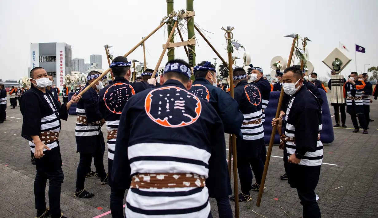 Anggota Asosiasi Pelestarian Pemadam Kebakaran Edo memegang tangga bambu saat melakukan teknik pemadam kebakaran tradisional Jepang saat latihan pemadam kebakaran Tahun Baru di Tokyo, Jepang, 6 Januari 2022. (Behrouz MEHRI/AFP)