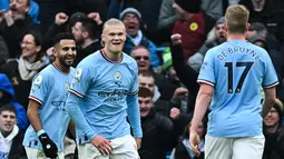 Erling Haaland (tengah) berselebrasi dengan rekan setimnya setelah mencetak gol pertama untuk Manchester City ke gawang Wolves selama pertandingan lanjutan Liga Inggris di Stadion Etihad di Manchester, Inggris (22/1/2023). Di pertandingan ini, Haaland mencetak tiga gol. (AFP/Paul Ellis)