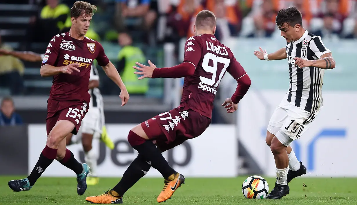 Striker Juventus, Paulo Dybala, berusaha melewati pemain Torino pada laga Serie A, Italia, di Stadion Allianz, Sabtu (23/9/2017). Juventus menang 4-0 atas Torino. (AFP/Filippo Monteforte)