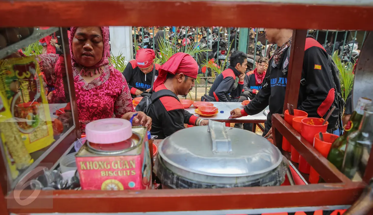 Buruh beristirahat sambil makan siang disela aksi demo di kawasan Istana Negara, Jakarta, Kamis (15/9). Ribuan buruh dari berbagai elemen organisasi menyatakan penolakan mereka terhadap paket kebijakan ekonomi jilid IV. (Liputan6.com/Faizal Fanani)