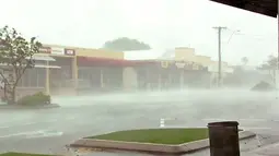 Gambar yang diambil dari video memperlihatkan hembusan angin di luar toko di Bowen, Australia timur, Selasa, (28/3). Badai yang mengembuskan angin hingga 161 km per jam memporak-porandakan puluhan bangunan di pesisir. (AuBC melalui AP)
