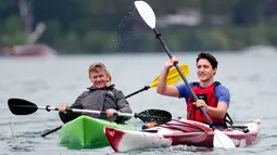 Seorang pria mengamati aksi PM Kanada Justin Trudeau saat mengayuh perahu kayak di sepanjang aliran Sungai Niagara, Ontario, Senin (5/6). Aksi PM Kanada ini untuk memperingati Hari Lingkungan Hidup Sedunia. (Nathan Denette/The Canadian Press via AP)