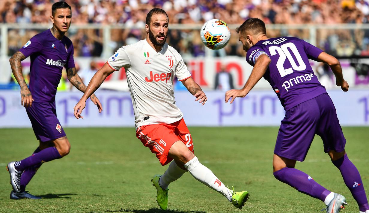 Striker Juventus, Gonzalo Higuain, berusaha melewati bek Fiorentina, German Pezzella, pada laga Serie A di Stadion Artemio Franchi, Florence, Sabtu (14/9). Kedua klub bermain imbang 0-0. (AFP/Vincenzo Pinto)