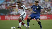 Mesut Ozil dibayangi Lucas Biglia (ADRIAN DENNIS / AFP)