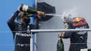 Pembalap Mercedes Lewis Hamilton (kiri) menyemprotkan sampanye kepada pembalap Red Bull Max Verstappen setelah memenangkan F1 GP Eifel di Nuerburgring, Nuerburg, Jerman, Minggu (11/10/2020). Hamilton dengan 91 kemenangannya menyamai legenda F1 Michael Schumacher. (Ronald Wittek, Pool via AP)