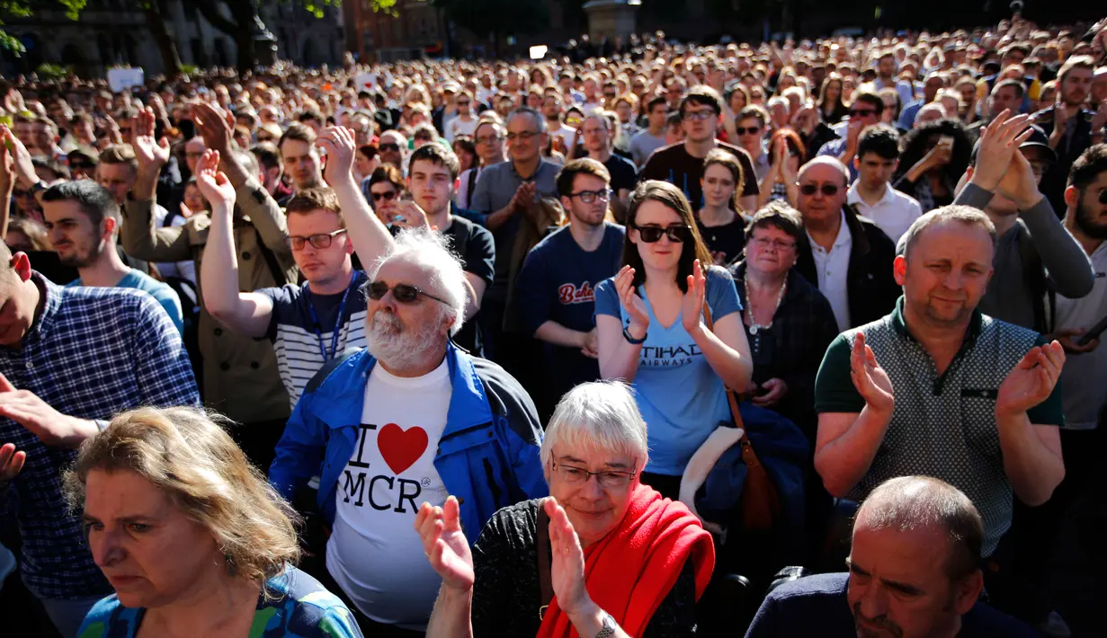Ribuan orang memadati Albert Square di pusat kota Manchester, sehari setelah teror bom bunuh diri saat konser Ariana Grande, Selasa (23/5). Mereka menunjukkan solidaritas terhadap korban serangan bom yang menewaskan 22 orang. (AP Photo/Emilio Morenatti)