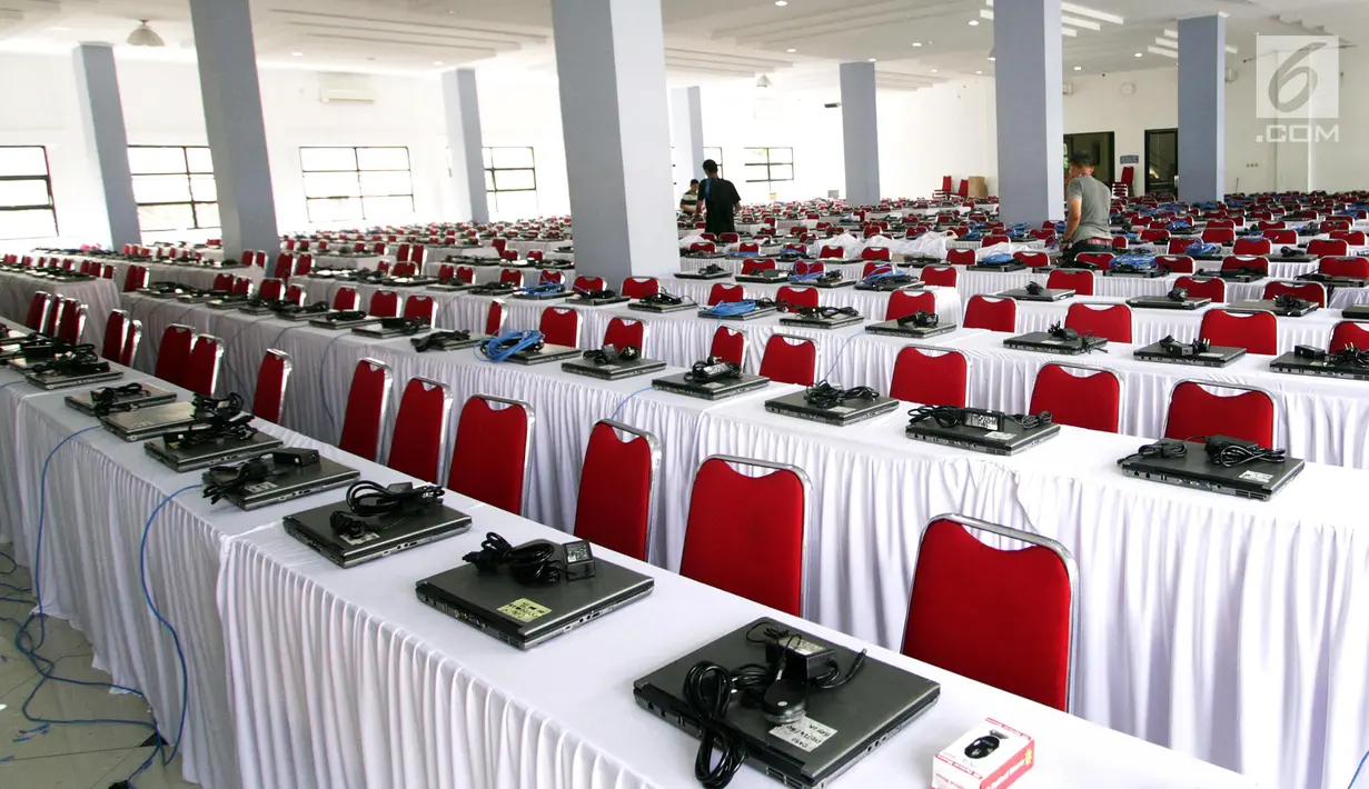 Teknisi menginstal laptop untuk tes calon pegawai negeri sipil (CPNS) di GOR Kelapa Gading, Jakarta Utara, Jumat (26/10). Tempat ini akan menjadi lokasi tes CPNS yang akan dilangsungkan pada Sabtu, 26 Oktober 2018. (Liputan6.com/JohanTallo)