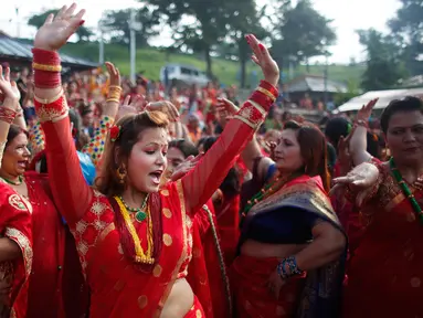 Wanita Hindu Nepal menari di kuil Pashupatinath selama festival Teej di Kathmandu, Nepal, Kamis (24/8). Festival ini ditujukan untuk wanita Hindu Nepal yang selama perayaan wajib berpuasa dan berdoa untuk kebahagiaan sang suami. (Niranjan Shrestha/AP)