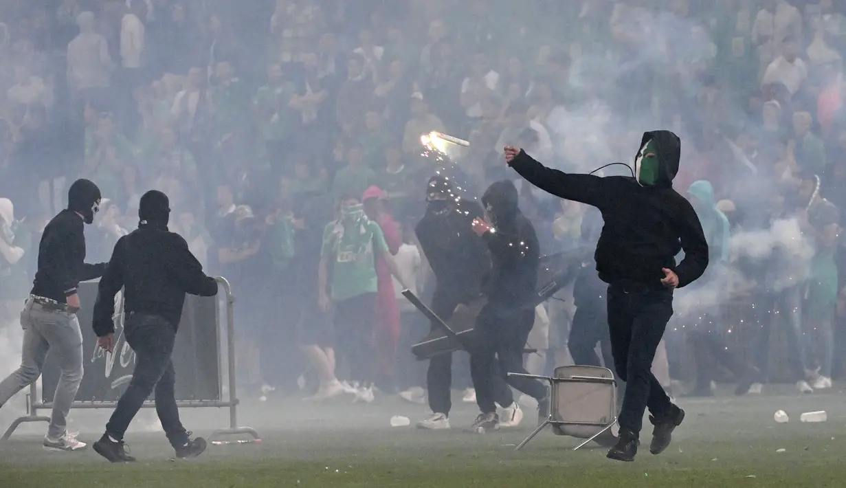 Suporter yang terlanjur mengamuk melampiaskan amarah kepada para pemain. Mereka melempari pemain Saint Etienne dengan flare. (AFP/Jean-Philippe Ksiazek)