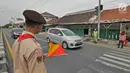 Anggota Pramuka membantu mengatur lalu lintas di jalur mudik kawasan pasar Surodadi, Tegal  Jawa Tengah, Senin (3/6/2019). Puluhan anggota Pramuka  membantu polisi mengatur lalu lintas selama arus mudik maupun arus balik. (Liputan6.com/Herman Zakharia)