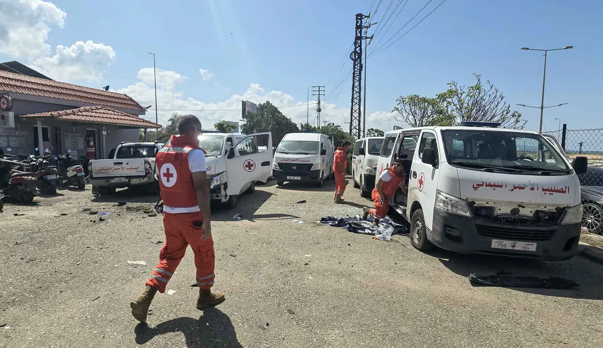 Sejumlah pihak menilai tindakan tersebut sebagai pelanggaran serius terhadap hukum humaniter internasional. Tampak dalam foto, para sukarelawan Palang Merah Lebanon memeriksa kerusakan pada kendaraan penyelamat di lokasi serangan pesawat tak berawak Israel yang menargetkan markas mereka di kota Tyre, Lebanon Selatan, Senin 13 April 2026. (Kawnat HAJU/AFP)