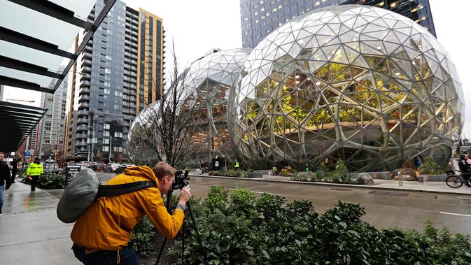 Alex Crook mengambil gambar kantor Amazon bernuansa hutan hujan yang baru, The Spheres, di Seattle, Senin (29/1). Di dalamnya dibuat seperti taman besar dengan ruang-ruang terbuka, sehingga tidak ada ruang konferensi yang tertutup. (AP/Ted S. Warren)