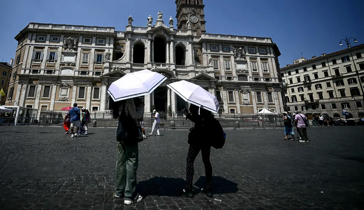 Dua orang membuka payung untuk melindungi diri dari terik matahari saat berdiri di depan Basilika Santa Maria Maggiore di pusat kota Roma pada 11 Agustus 2025. (Filippo MONTEFORTE/AFP)