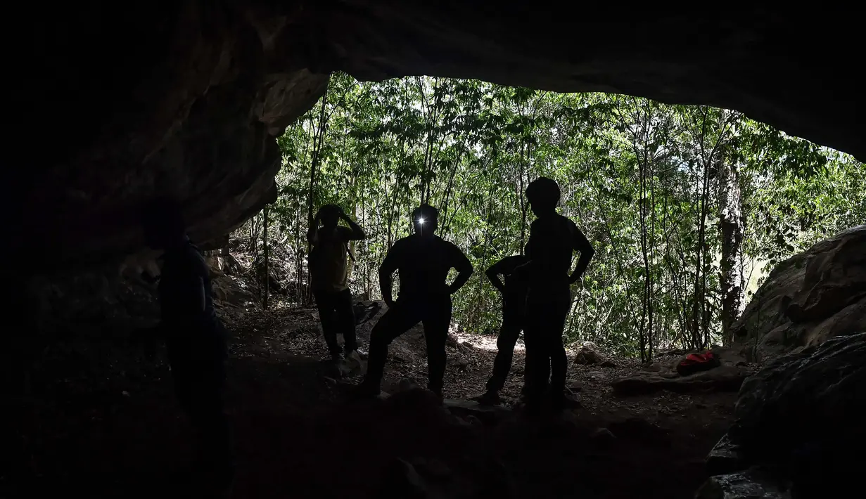 Arkeolog dari Departemen Seni Rupa di Ratchaburi melihat lukisan gua yang baru ditemukan di taman nasional Khao Sam Roi Yot di pesisir provinsi Prachuap Kiri Khan (10/9/2020). Antelop, sosok kesepian, keluarga yang saling bergandengan tangan. (AFP/Lillian Suwanrumpha)