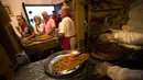 Karyawan meniriskan donat khas Spanyol atau churros usai digoreng di restoran dessert tradisional La Manueta, Pamplona, Spanyol, Rabu (10/7/2019). Churros memiliki tekstur renyah diluar dan lembut di dalam. (JAIME REINA/AFP)