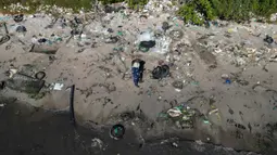 Mereka menyusuri pantai Pulau Pombeba, Teluk Guanabara, Rio de Janeiro, Brasil.untuk mengumpulkan sampah. (Pablo PORCIUNCULA/AFP)