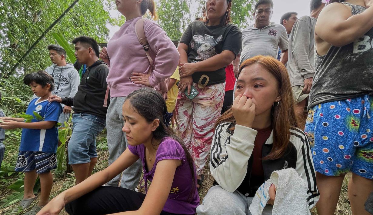 Untuk diketahui, tempat pembuangan sampah ini dikelola oleh perusahaan swasta. Tampak dalam foto, kerabat korban bersama sejumlah warga lainnya menunggu kabar terbaru setelah tumpukan sampah besar runtuh di fasilitas pemilahan sampah di Binaliw, Kota Cebu, Filipina, Jumat 9 Januari 2026. (AP Photo/Jacqueline Hernandez)