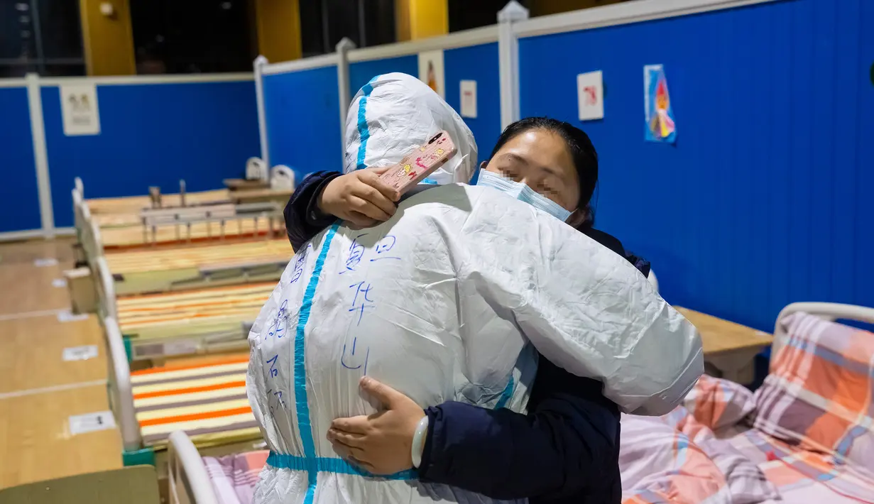 Pasien virus corona atau COVID-19 Ying memeluk petugas medis Cao Jinglei di sebuah rumah sakit sementara di Wuhan, China, Senin (9/3/2020). China menutup semua rumah sakit sementara yang dibuat untuk menangani virus corona di Kota Wuhan.  (Xinhua/Shen Bohan)