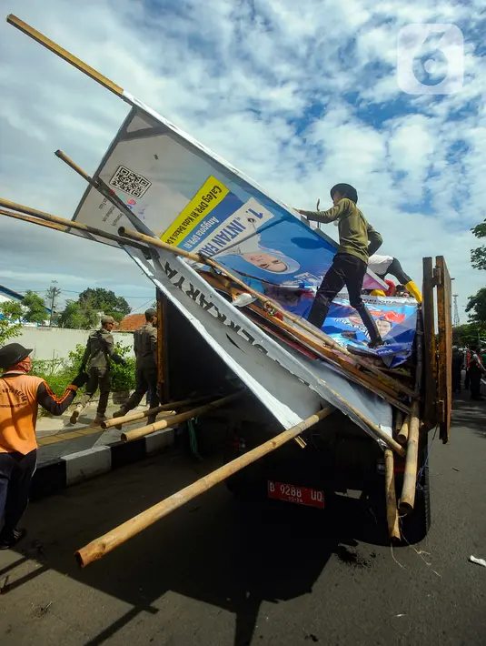 <p>Setelah dicopot atau diturunkan, baliho kampanye tersebut kemudian diangkut menggunakan truk untuk diamankan. (merdeka.com/Arie Basuki)</p>