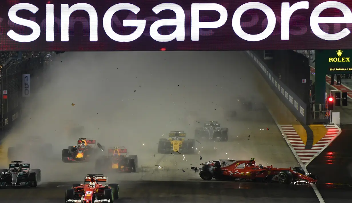 Pembalap Finlandia Ferrari Kimi Raikkonen (kanan) kecelakaan saat pembalap Ferrari asal Jerman, Sebastian Vettel memimpin pada Grand Prix Singapura Formula One di Sirkuit Marina Bay City, Singapura, Minggu, (17/09) (MANAN VATSYAYANA / AFP)