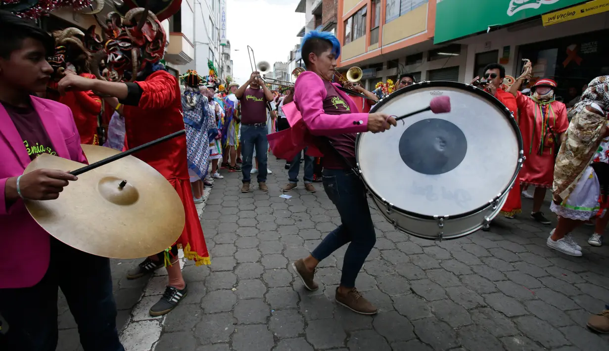 Sejumlah musisi meramaikan festival  La Diablada di jalan-jalan kota Pillaro, Ekuador, Jumat (4/1). Pada kesempatan itu, warga tumpah ruah di pusat kota sembari mengenakan kostum merah dan bertopeng setan. (AP/Dolores Ochoa)