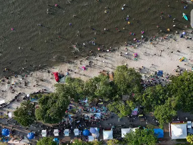 Foto udara memperlihatkan warga yang berwisata saat libur lebaran di Pantai Lagoon Taman Impian Ancol, Jakarta, Kamis (11/4/2024). (Liputan6.com/Herman Zakharia)