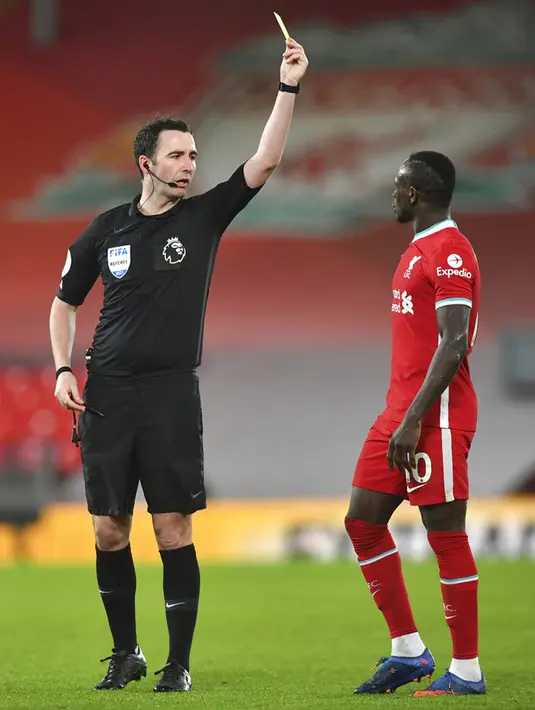 Wasit Chris Kavanagh menunjukkan kartu kuning kepada pemain Liverpool Sadio Mane pada pertandingan Liga Inggris di Anfield, Liverpool, Inggris, Sabtu (20/2/2021). Liverpool kalah 0-2. (Paul Ellis/Pool via AP)
