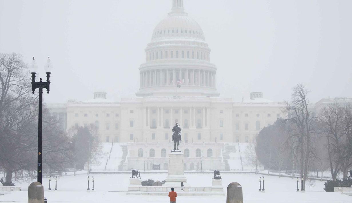 Layanan Cuaca Nasional memperingatkan bahwa ketebalan salju akhir bisa mencapai 14 inci di New York City pada Senin 26 Agustus 2026, jumlah salju tertinggi sejak 2021. Tampak dalam foto, pemandangan Gedung Capitol AS saat salju turun di Washington, DC, pada Minggu 25 Januari 2026. (Amid FARAHI/AFP)