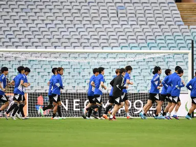 Para pemain Jepang melakukan pemanasan saat mengikuti sesi latihan di Stadium Australia di Sydney (23/3/2022). Jepang akan bertanding melawan Australia pada kualifikasi Grup B Piala Dunia Qatar 2022 zona Asia pada Kamis (24/3/2022) di Stadion Australia. (AFP/Saeed Khan)