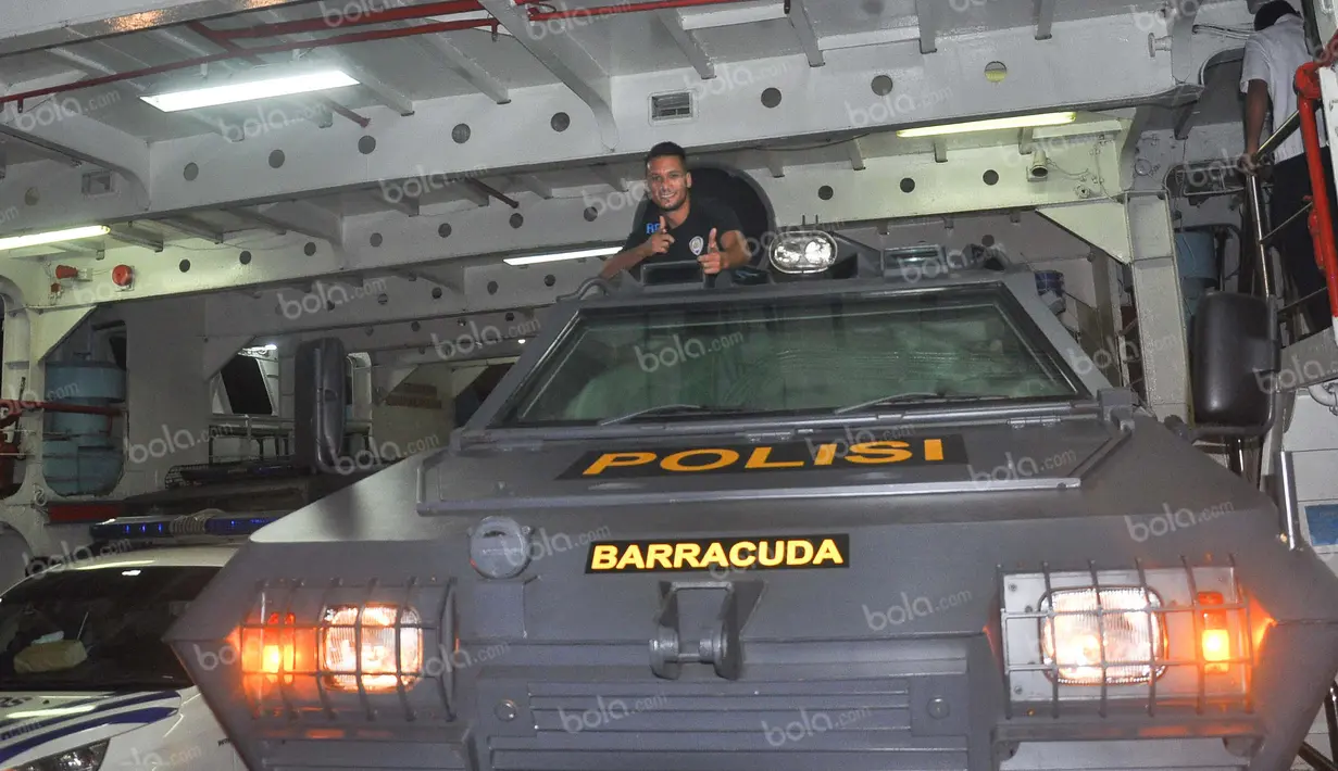 Pemain Arema Cronus, Raphael Maitimo, berpose di atas mobil rantis Polri di dalam kapal feri usai bertanding melawan Madura United di Stadion Gelora Bangkalan, Jumat (6/5/2016). (Bola.com/Iwan Setiawan)