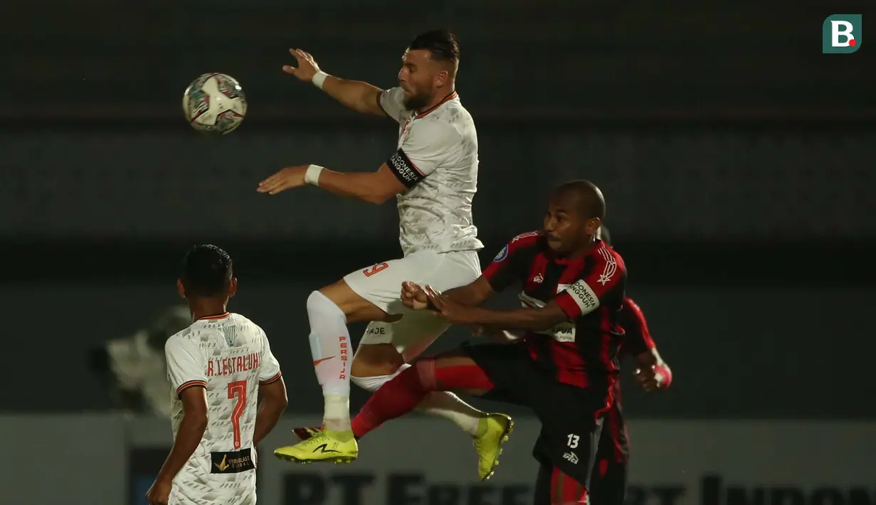 Pemain Persija Jakarta, Marko Simic (tengah) berebut bola di udara dengan pemain Persipura Jayapura, Ian Louis Kabes dalam laga pekan ke-3 BRI Liga 1 2021/2022 di Stadion Indomilk Arena, Tangerang, Minggu (19/9/2021). Kedua tim bermain imbang 0-0. (Bola.com/Ikhwan Yanuar)