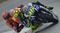 Ketegangan berlanjut saat Rossi mampu meraih juara pada MotoGP Belanda 2015 yang berlangsung di Sirkuit Assen. Rossi dinilai melakukan hal kontroversial usai menyalip Marquez lewat 'jalan pintas' atau gravel di lap terakhir untuk merebut posisi terdepan. (AFP/Glyn Kirk)