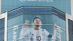Gambar besar kapten Argentina Lionel Messi dipajang di sebuah gedung jelang Piala Dunia 2022 di Doha, Qatar, Minggu (6/11/2022). Piala Dunia 2022 akan dimulai pada 20 November 2022 hingga 18 Desember dengan menampilkan pertandingan pembuka antara tuan rumah Qatar vs Ekuador pada 20 November 2022. (Gabriel BOUYS/AFP)
