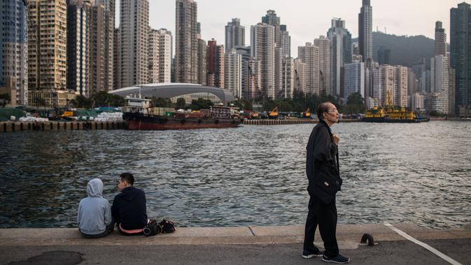 Orang-orang bersantai di dermaga umum di sebelah Pelabuhan Victoria di Hong Kong (3/3). Pemandangan yang spektakuler membuat pelabuhan ini menjadi daya tarik wisata utama Hong Kong. (AFP Photo/Dale De La Rey)