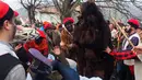 Seorang pria mengenakan kostum beruang menghibur warga dalam Fete de l'kita atau Festival Beruang di Saint-Laurent-de-Cerdans, Prancis (12/2). Dalam perayaan ini ikut juga sejumlah orang yang berperan sebagai pemburu beruang. (AFP/Raymond Roig)