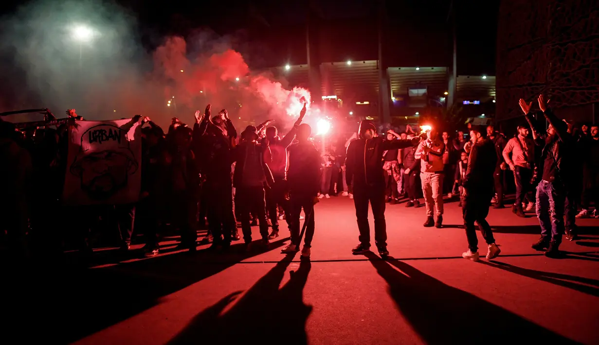 <p>Suporter Paris Saint-Germain (PSG) pergi setelah merayakan gelar Ligue 1 Prancis klub mereka kontra Lens di luar Parc des Princes, Minggu (24/4/2022) dini hari WIB. PSG juarai Liga Prancis untuk ke-10 kali meski ditahan seri Lens 1-1. (JULIEN DE ROSA / AFP)</p>