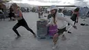 Pengunjung berlari saat mengikuti Carnival of Death dalam festival Burning Man 2015 di Gurun Black Rock, Nevada, (3/9/2015). Partisipan dari seluruh dunia hadiri festival seni unik ini selama sepekan. (REUTERS/Jim Urquhart)