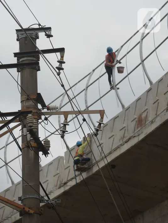 Pekerja beraktivitas di proyek pembangunan jalan layang (flyover) Cakung, Jakarta, Kamis (28/1/2021). Pembangunan jalan  layang dengan panjang 760 meter dan lebar 18 meter ini bertujuan sebagai pengganti pelintasan sebidang kereta api. (merdeka.com/Imam Buhori)