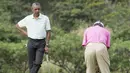 Presiden AS Barack Obama memperhatikan PM Malaysia, Najib Razak melakukan put di lubang ke 18 saat bermain golf di Hawaii, Rabu (24/12/2014). (AFP PHOTO/Nicholas KAMM)