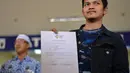 Mahasiswa yang dipulangkan dari karantina virus corona atau COVID-19 di Natuna menunjukkan surat dari Kementerian Kesehatan Indonesia saat tiba di Bandara Internasional Sultan Iskandar Muda, Blang Bintang, Aceh, Senin (17/2/2020). Hari ini, dijadwalkan 8 orang tiba di Aceh. (CHAIDEER MAHYUDDIN/AFP)