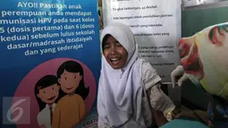 Ekspresi seorang anak saat mengikuti Bulan Imunisasi Anak sekolah (BIAS) di SDN 11 Pagi, Lubang Buaya, Jakarta, Selasa (4/10). Kegiatan ini untuk mewujudkan Indonesia bebas dari kanker serviks. (Liputan6.com/Faizal Fanani)