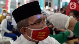 Warga menjalani pemeriksaan suhu tubuh sebelum disuntik vaksin COVID-19 Moderna oleh petugas kesehatan di Puskesmas Kramat Jati, Jakarta, Jumat (20/8/2021). Bagi masyarakat umum, saat ini diperbolehkan mendapat vaksin COVID-19 Moderna untuk menekan penyebaran virus corona. (merdeka.com/Imam Buhori)