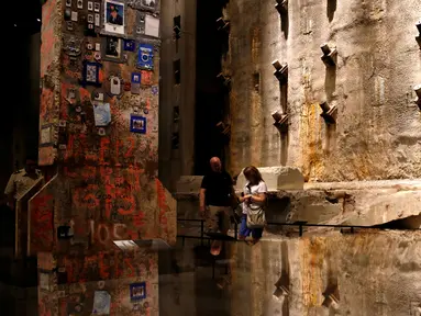 Pengunjung melihat "The Last Column" di depan dinding asli World Trade Center di National September 11 Memorial and Museum, Manhattan, AS (1/9). Pameran ini  diberi nama 'Rendering the Unthinkable: Artists Respond to 9/11'. (REUTERS/Andrew Kelly)