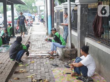 Pengemudi ojek daring menunggu order di depan Cibubur Junction, Jakarta, Selasa (24/3/2020). Merebaknya corona Covid-19 menyebabkan aktivitas di kawasan itu lesu yang juga berimbas pada turunnya pendapatan pengemudi ojol hingga lima kali lipat dibanding hari biasanya (Liputan6.com/Immanuel Antonius)