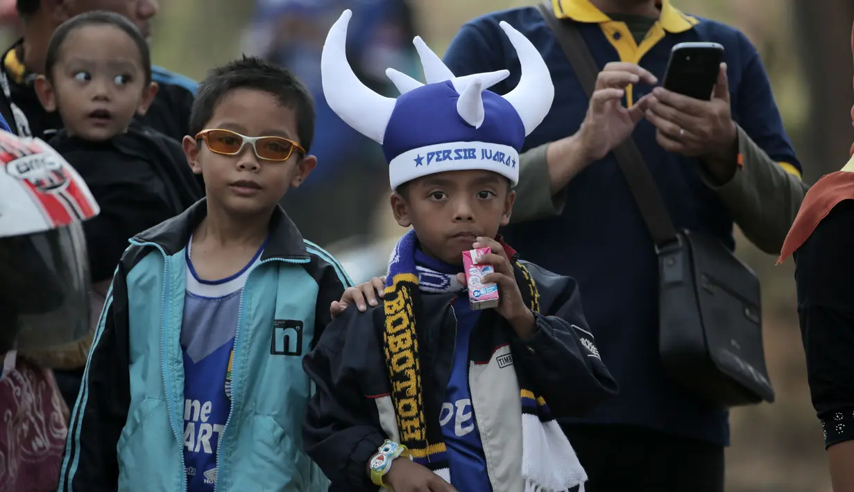 Anak-anak ditemani orang tua hadir dalam acara parade Persib Bandung Juara Piala Presiden 2015 di Kota Baru, Bandung, Minggu (25/10/2015). (Bola.com / Nicklas Hanoatubun)