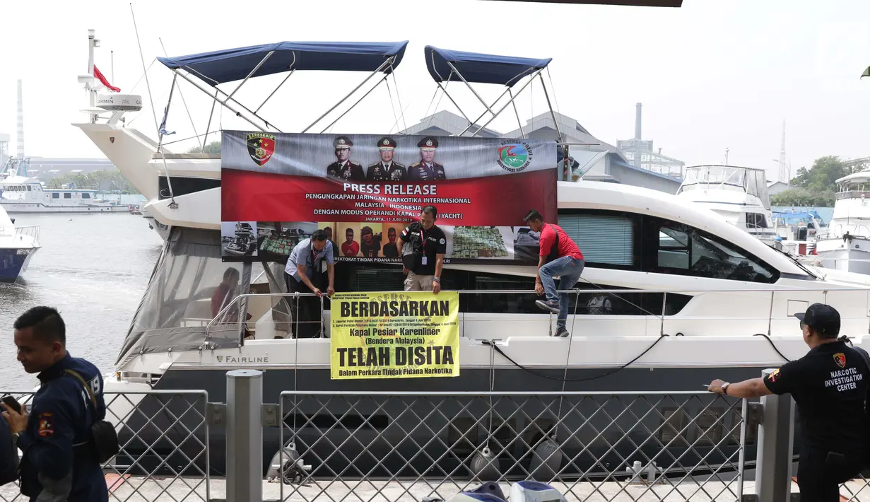 Petugas Dirtidpid Bareskrim Polri memasang spanduk penyitaan kapal pesiar Karenliner di Pelabuhan Batavia Marina, Jakarta, Selasa (11/6/2019). Dirtidpid Narkoba Bareskrim Polri mengungkap penyelundupan 37 kg sabu asal Malaysia sabu dengan menggunakan kapal pesiar. (Liputan6.com/Helmi Fithriansyah)