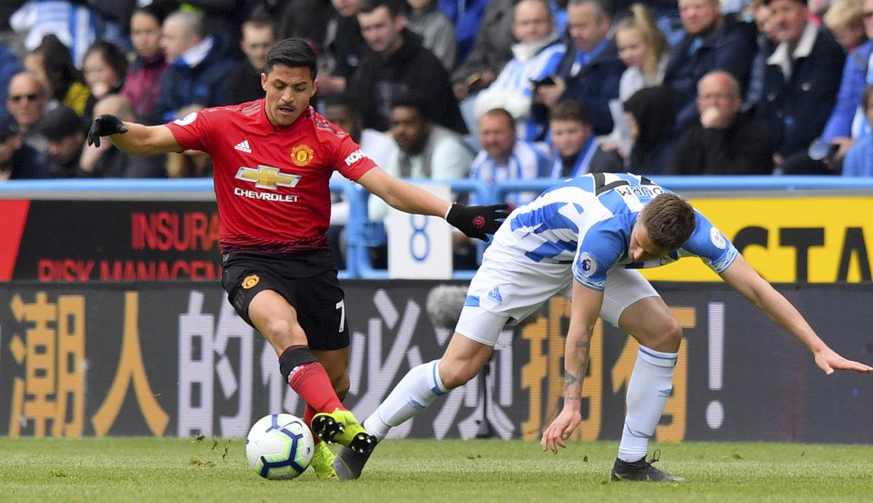 Penyerang Manchester United, Alexis Sanchez, berusaha melewati pemain Huddersfield Town, Erik Durm, pada laga Premier League di Stadion John Smith, Minggu (5/5). Kedua tim bermain imbang 1-1. (AP/Anthony Devlin)