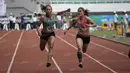 Atlet Jawa Timur, Tri Setyo Utami (kiri), meraih emas lari 100m putri PON XIX Jawa Barat 2016 setelah mengalahkan atlet Sumatra Barat, Lusiana Satriani (kanan) dalam final di Stadion Pakansari, Bogor, Kamis (22/9/2016). (Bola.com/Arief Bagus)