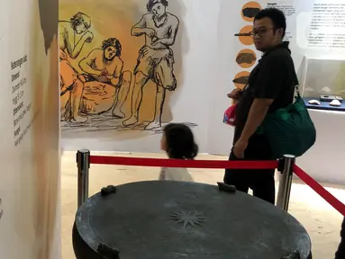 Pengunjung melihat bejana dandang perunggu pada pameran Asal Usul Orang Indonesia (ASOI) di Museum Nasional Jakarta, Minggu (3/11/2019). ASOI merupakan pameran yang menampilkan fase perkembangan manusia purba mulai dari Homo Erectus Tipik hingga Homo Sapiens. (Liputan6.com/Fery Pradolo)